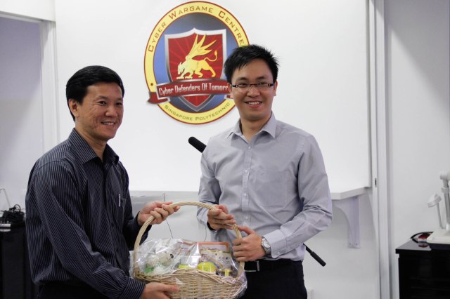 Mr Liew presenting a home-made SP gift hamper  to Mr Huynh