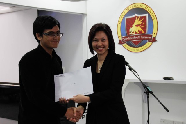 DMIT Director Ms Georgina Phua presenting Certificate of Participation in DISM CTF S1 to year 2 student Suhaimi
