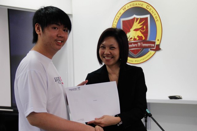 DMIT Director Ms Georgina Phua presenting Certificate of Participation in DISM CTF S1 to year 3 student Lee Xin En