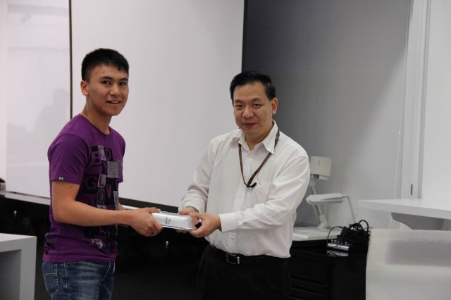 New ISACA Student Member and lucky draw winner Mustaqiim receiving prize from DISM lecturer Mr Samson Yeow